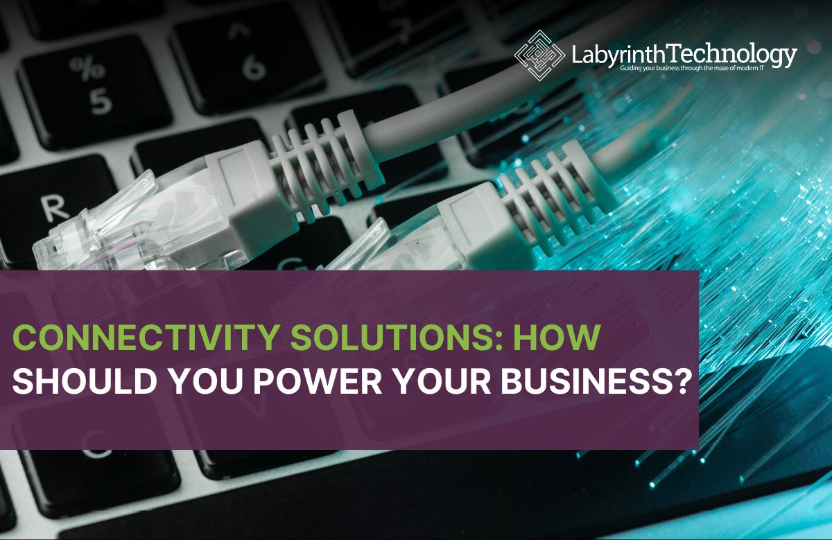 A photo of fibre optic wires on a laptop keyboard. the text reads "Connectivity Solutions: How Should You Power Your Business?." The Labyrinth Technology logo is in the top right