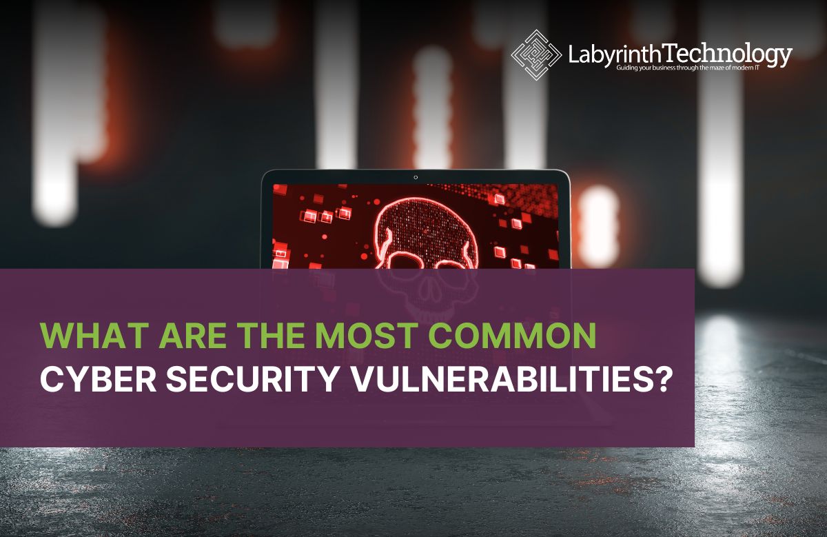 Open laptop on a dark surface displaying a red skull graphic on the screen, with blurred vertical lights in the background. The Labyrinth Technology logo is in the top right. The text reads "what are the most common cyber security vulnerabilities?"