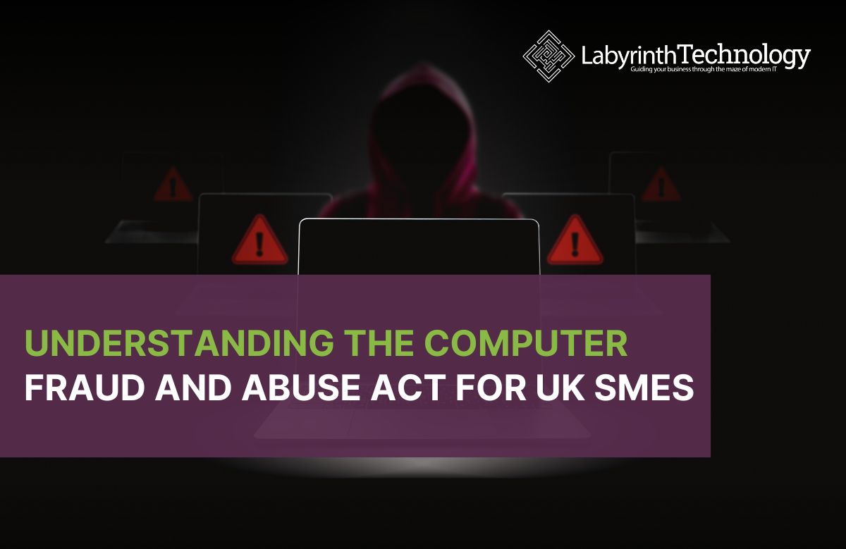 Shady person in the background with 2 error/danger symbols on monitors either side of them and a laptop in the foreground. The Labyrinth Technology logo is in the top right. The text reads "Understanding the Computer Fraud and Abuse Act for UK SMEs"