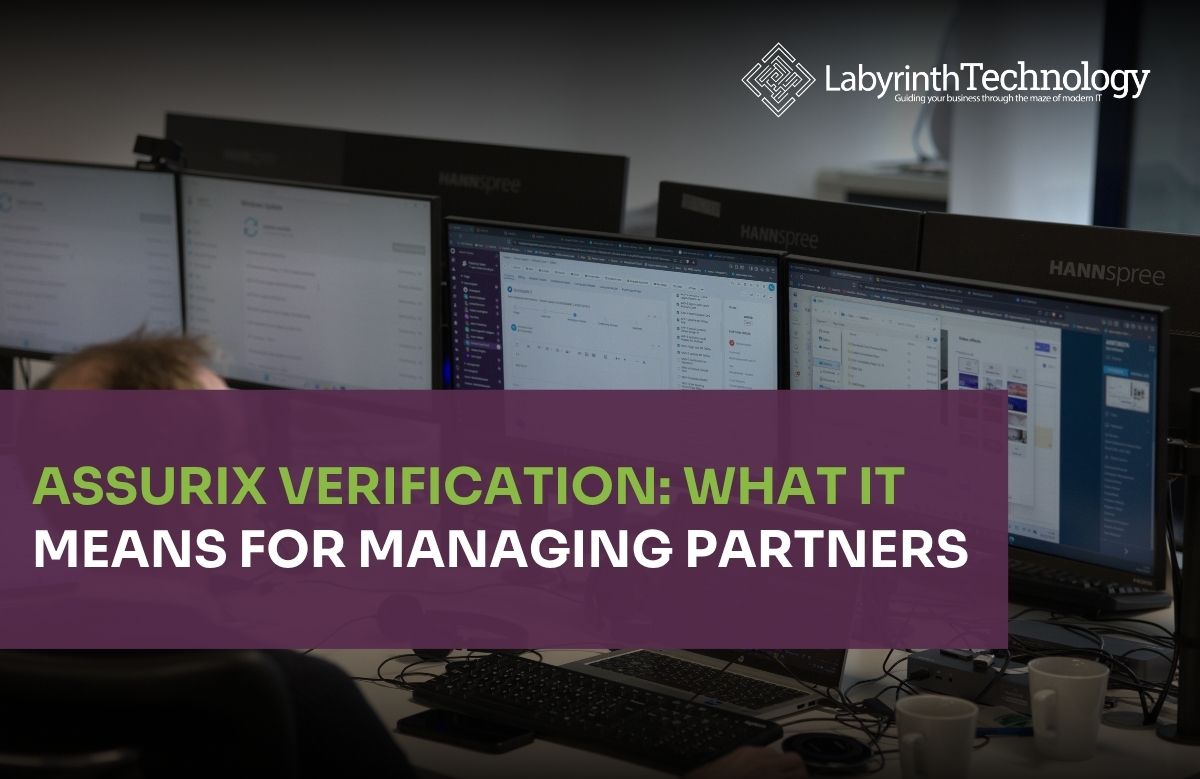 A man in the foreground working on his laptop and 2 large monitors. The Labyrinth Technology logo is in the top right corner. The text in bottom left says "Assurix Verification: What It Means for Managing Partners"